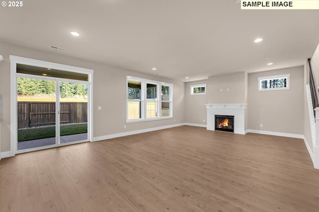 17301 SW Atfalati Ln Unit 38, Sherwood, OR 97140 - unfurnished living room with wood finished floors, recessed lighting, and a glass covered fireplace