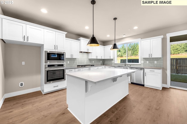 17301 SW Atfalati Ln Unit 38, Sherwood, OR 97140 - kitchen featuring appliances with stainless steel finishes, white cabinetry, light wood-type flooring, and recessed lighting