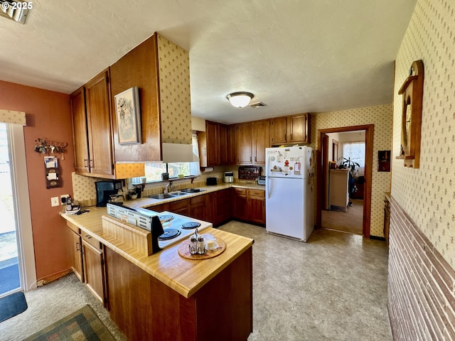 330 Maple St, Brookings, OR 97415 - kitchen featuring freestanding refrigerator, wallpapered walls, light countertops, plenty of natural light, and a peninsula