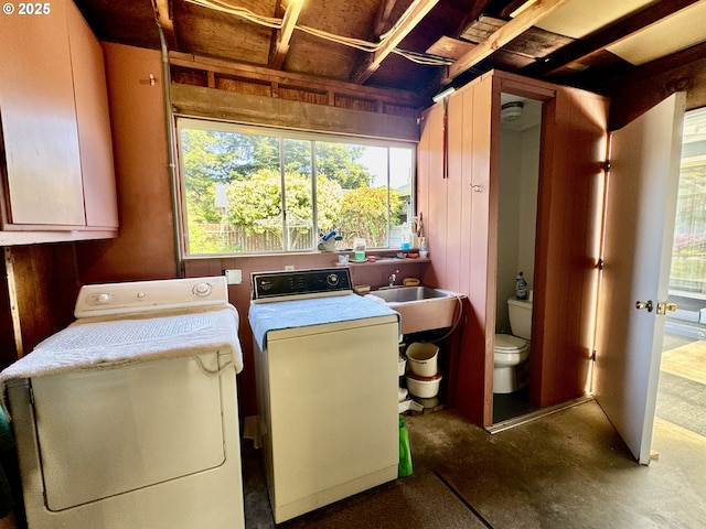 330 Maple St, Brookings, OR 97415 - washroom with cabinet space, washer and clothes dryer, healthy amount of natural light, and wooden walls
