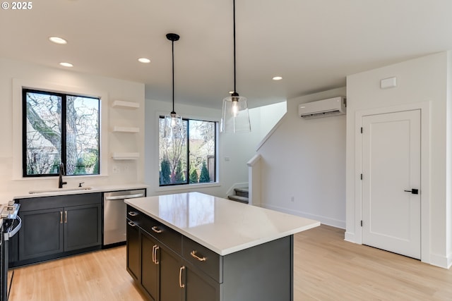 kitchen featuring sink, a wall unit AC, a kitchen island, decorative light fixtures, and stainless steel dishwasher