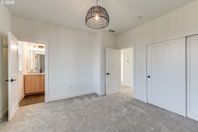 unfurnished bedroom with light colored carpet and a closet