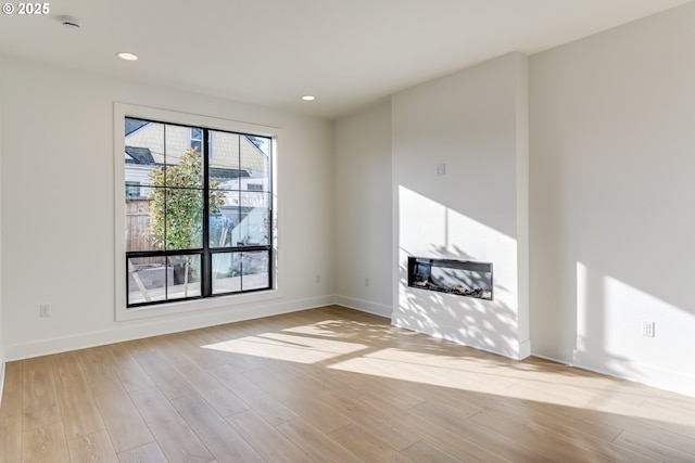 unfurnished living room with light hardwood / wood-style floors and a healthy amount of sunlight