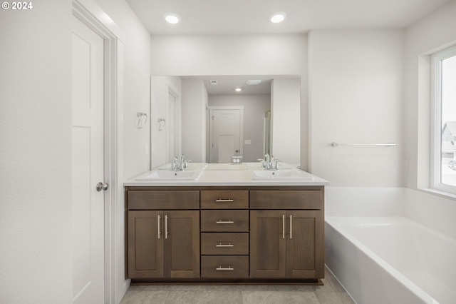 full bathroom featuring recessed lighting, a garden tub, a sink, and double vanity