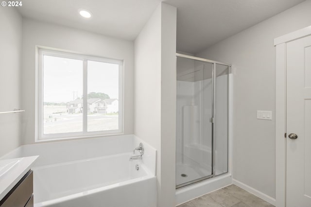 full bath with a shower stall, vanity, tile patterned flooring, baseboards, and a bath