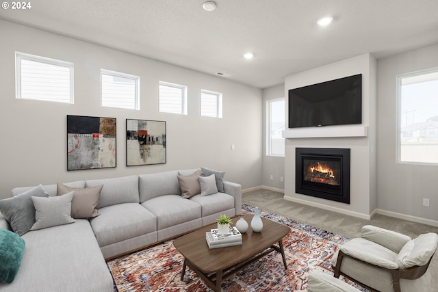 living room with visible vents, baseboards, a glass covered fireplace, carpet, and recessed lighting