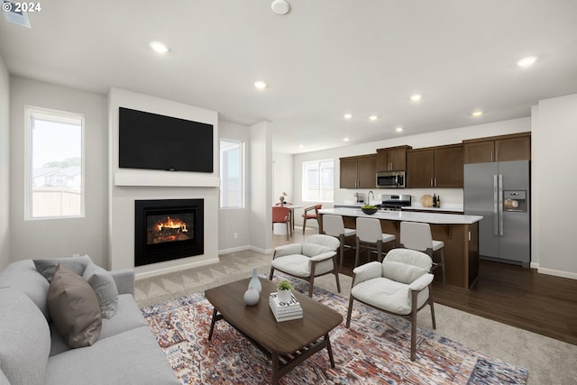 living room featuring baseboards, a glass covered fireplace, and recessed lighting