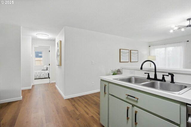 kitchen with green cabinets, light countertops, a healthy amount of sunlight, and a sink
