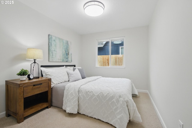 bedroom with light carpet and baseboards