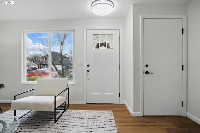 foyer entrance with wood finished floors and baseboards