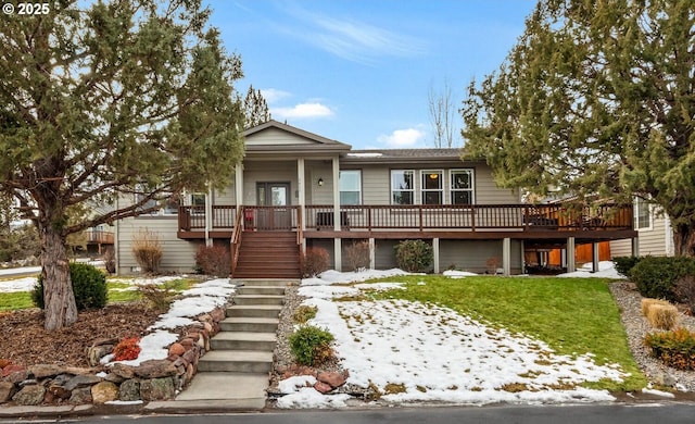 view of front of house featuring a deck, a yard, and stairway