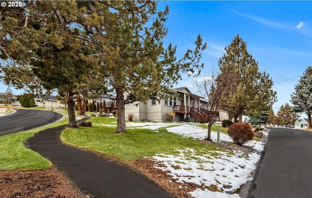 view of front of house with stairs, a residential view, and a front yard