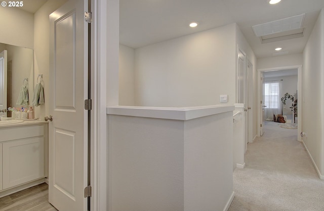 hallway featuring light carpet and sink