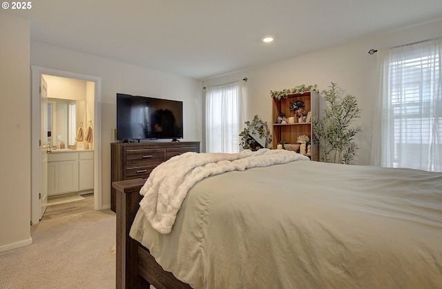 carpeted bedroom featuring sink and ensuite bath