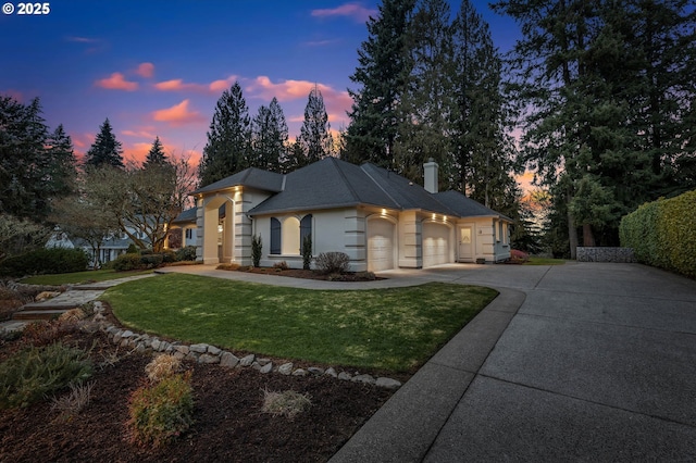 view of front of house with a garage and a lawn