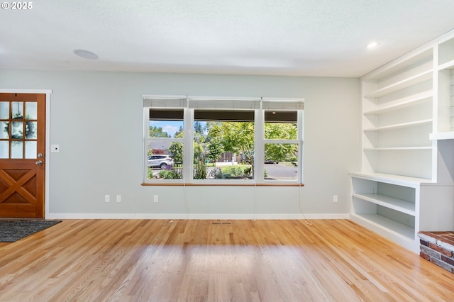9885 SW Bonnie Brae Dr, Beaverton, OR 97008 - unfurnished living room with wood finished floors, baseboards, and built in shelves