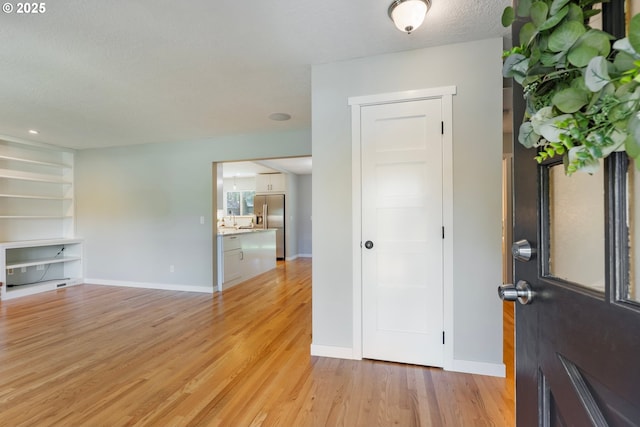 9885 SW Bonnie Brae Dr, Beaverton, OR 97008 - foyer entrance with light wood-style flooring, baseboards, and a textured ceiling