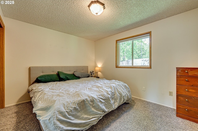 carpeted bedroom with a textured ceiling and baseboards