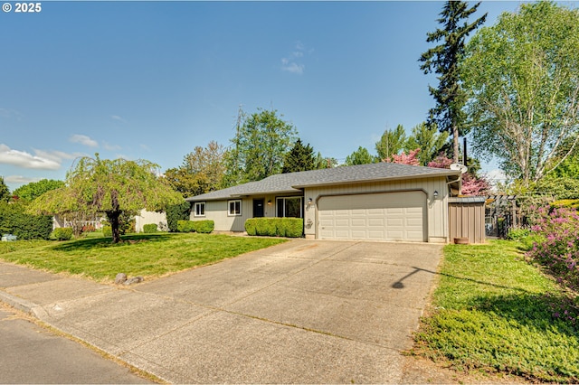 ranch-style house featuring an attached garage, fence, driveway, and a front yard