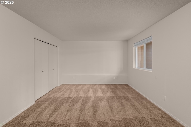 carpeted spare room with a textured ceiling