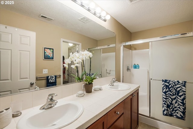 16181 SW Holland Ln, Sherwood, OR 97140 - bathroom featuring a shower stall, double vanity, and a textured ceiling