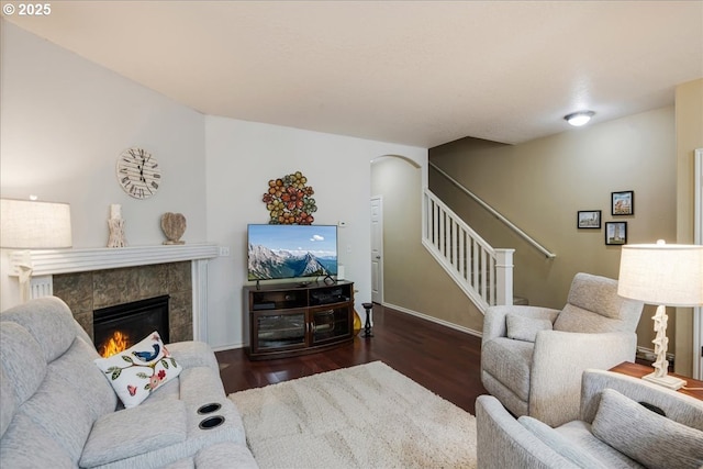 16181 SW Holland Ln, Sherwood, OR 97140 - living room featuring wood finished floors, stairs, a tiled fireplace, baseboards, and arched walkways