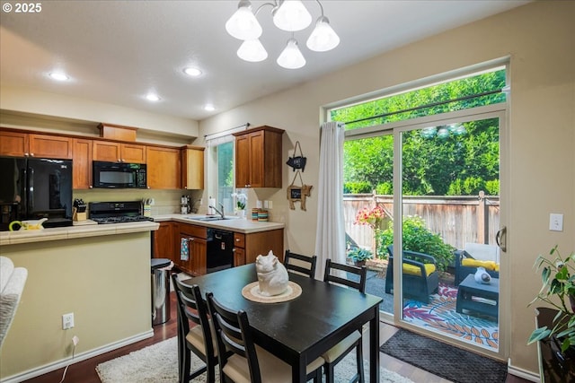 16181 SW Holland Ln, Sherwood, OR 97140 - kitchen with black appliances, a chandelier, brown cabinets, a sink, and recessed lighting