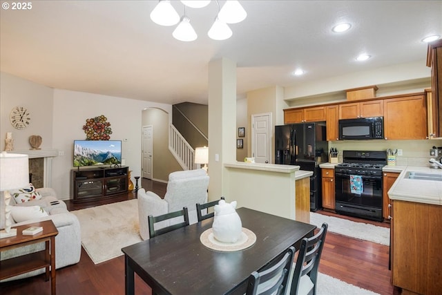 16181 SW Holland Ln, Sherwood, OR 97140 - dining area featuring stairs, dark wood finished floors, arched walkways, a chandelier, and recessed lighting