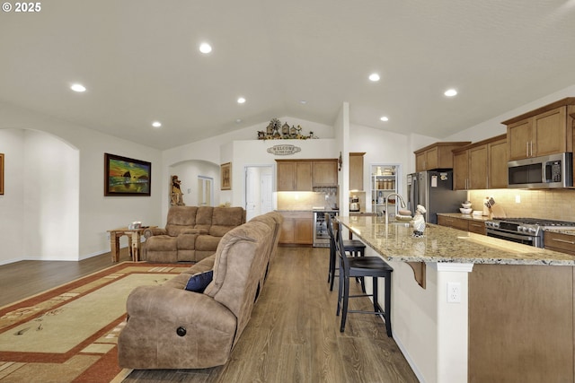 760 S 52nd St, Springfield, OR 97478 - living room with arched walkways, wine cooler, dark wood-style flooring, vaulted ceiling, and recessed lighting