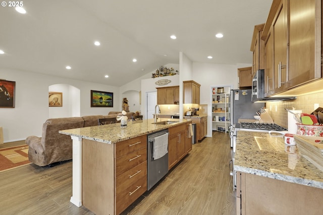760 S 52nd St, Springfield, OR 97478 - kitchen with arched walkways, a sink, appliances with stainless steel finishes, open floor plan, and backsplash