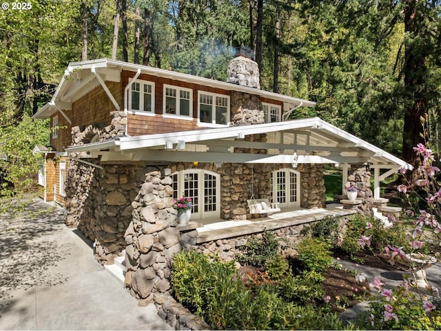 49 Briarwood Rd, Lake Oswego, OR 97034 - view of front of house with french doors, stone siding, a chimney, and a patio area