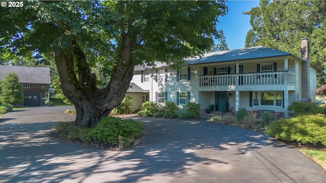 8758 Thurston Rd, Springfield, OR 97478 - view of front facade with a chimney, a balcony, driveway, and a porch