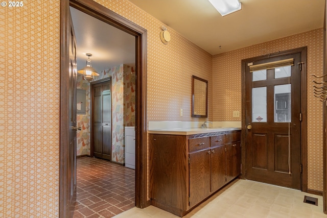 8758 Thurston Rd, Springfield, OR 97478 - kitchen featuring wallpapered walls, light countertops, washer / dryer, and brick patterned flooring