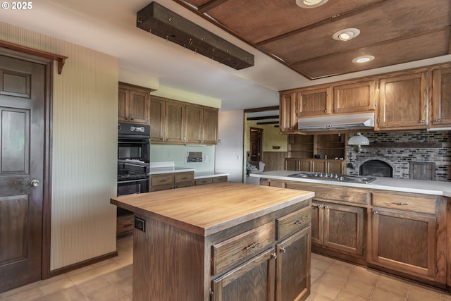 8758 Thurston Rd, Springfield, OR 97478 - kitchen with wooden counters, under cabinet range hood, decorative backsplash, a center island, and stainless steel gas cooktop