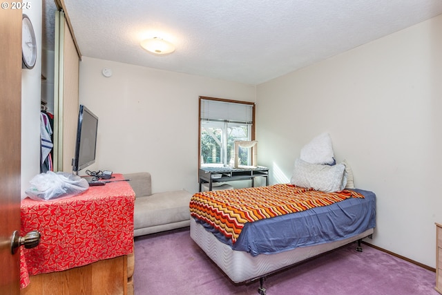 bedroom featuring baseboards, carpet, and a textured ceiling