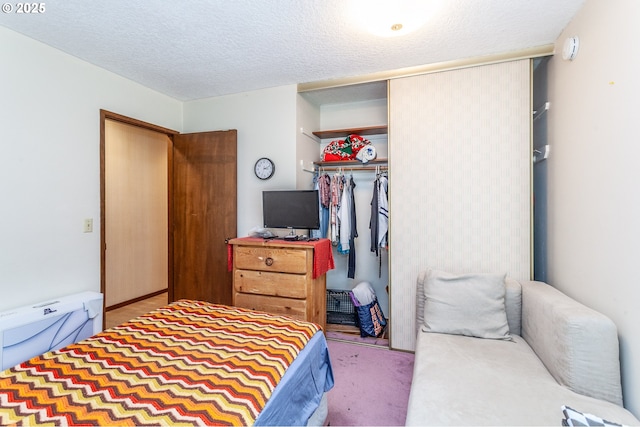 bedroom with a closet, a textured ceiling, and carpet floors