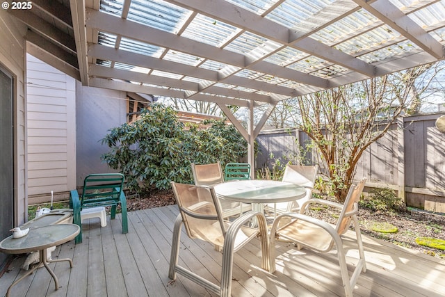 wooden deck featuring outdoor dining space, a pergola, and fence