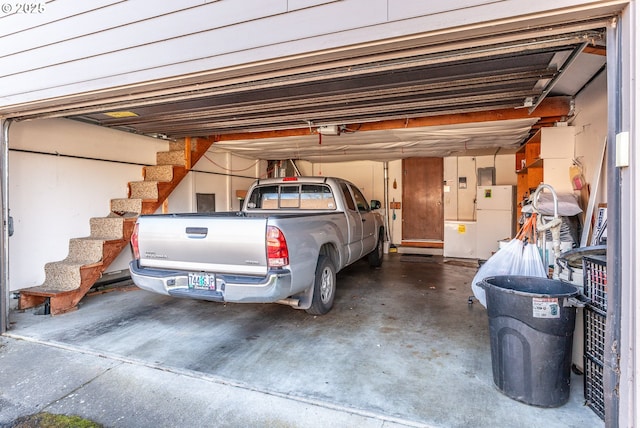 garage with a garage door opener and freestanding refrigerator