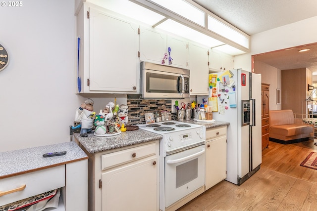 kitchen with decorative backsplash, white appliances, light wood-style floors, and light countertops