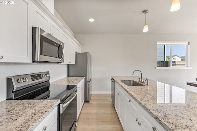 1502 Timothy St, Philomath, OR 97370 - kitchen with appliances with stainless steel finishes, a sink, white cabinetry, decorative backsplash, and light wood-style flooring