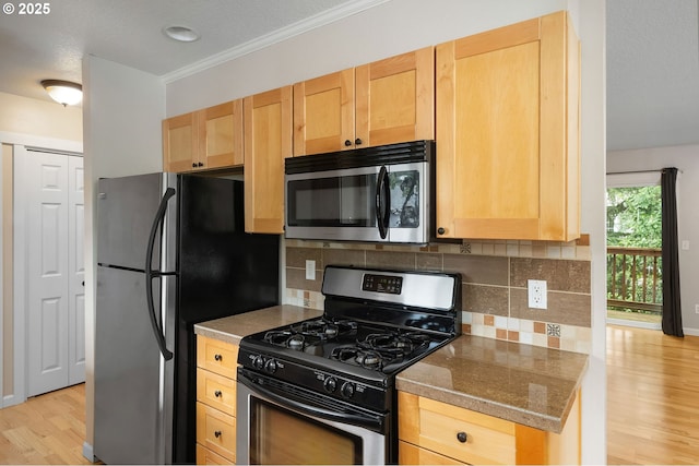 3925 SW Multnomah Blvd Unit 204, Portland, OR 97219 - kitchen with appliances with stainless steel finishes, light wood-style flooring, light brown cabinetry, decorative backsplash, and crown molding