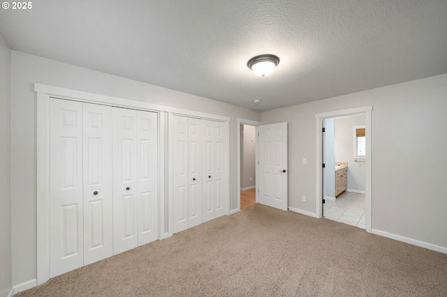 3925 SW Multnomah Blvd Unit 204, Portland, OR 97219 - unfurnished bedroom featuring light carpet, baseboards, a textured ceiling, and ensuite bath