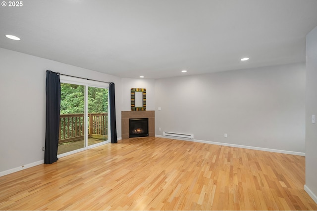 3925 SW Multnomah Blvd Unit 204, Portland, OR 97219 - unfurnished living room with a baseboard heating unit, light wood finished floors, a tile fireplace, baseboards, and recessed lighting