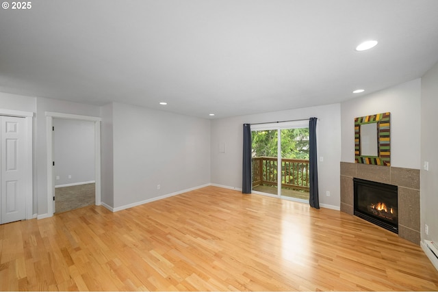 3925 SW Multnomah Blvd Unit 204, Portland, OR 97219 - unfurnished living room with wood finished floors, a tile fireplace, recessed lighting, baseboard heating, and baseboards