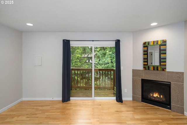 3925 SW Multnomah Blvd Unit 204, Portland, OR 97219 - unfurnished living room with wood finished floors, a fireplace, recessed lighting, and baseboards