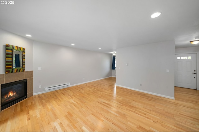 3925 SW Multnomah Blvd Unit 204, Portland, OR 97219 - unfurnished living room featuring baseboard heating, light wood-style flooring, a fireplace, recessed lighting, and baseboards