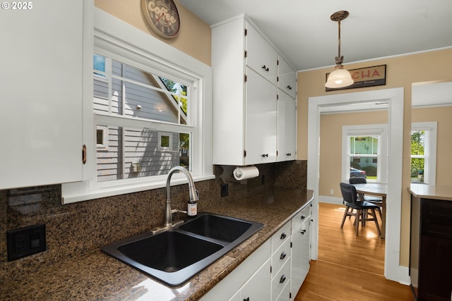 3305 NE Siskiyou St, Portland, OR 97212 - kitchen featuring a sink, tasteful backsplash, light wood-type flooring, and white cabinets