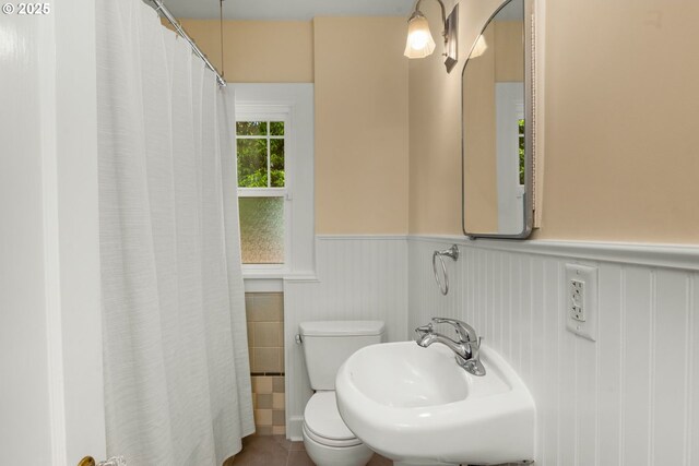3305 NE Siskiyou St, Portland, OR 97212 - bathroom featuring wainscoting, toilet, a sink, a shower with shower curtain, and tile patterned floors
