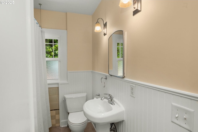 3305 NE Siskiyou St, Portland, OR 97212 - bathroom featuring a wainscoted wall, toilet, a sink, and a shower with curtain