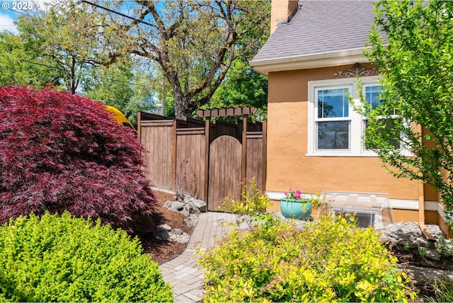 3305 NE Siskiyou St, Portland, OR 97212 - view of side of property with stucco siding, a chimney, and roof with shingles